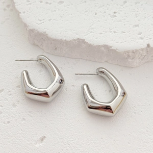 Minimalist silver geometric U-shaped hollow earrings shown on a white stone pedestal