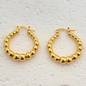 Boucles d'oreilles créoles perlées plaquées or 18 carats sur fond de pierre blanche