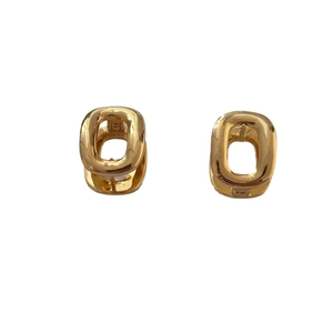 Modern chunky gold oval hoop earrings with a high-polished finish on white background