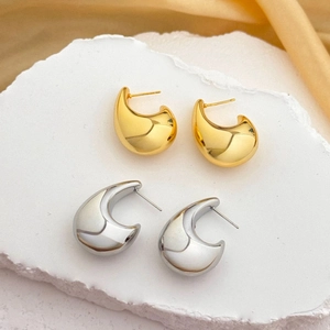 Polierte geometrische hohle Mondsichel-Ohrringe in Gold und Silber auf Stein