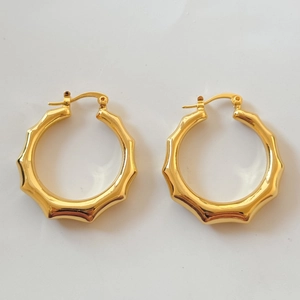 Détails de boucles d'oreilles créoles bambou plaquées or avec texture lisse et fermoir