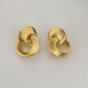 Macro detail of gold-plated hoop earrings featuring horizontal spiral texture and layers