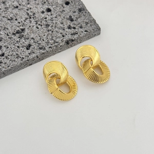 Irregular textured geometric gold interlocking earrings on minimalist background