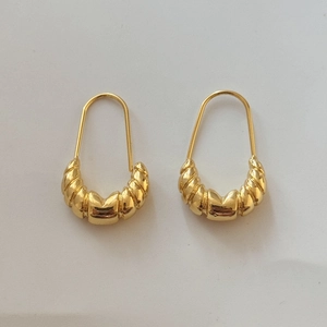 Detail of gold twisted croissant hoop earrings with slim U-shaped hanging hooks