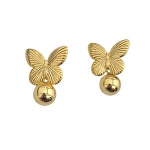 Boucles d'oreilles papillon dorées avec boules métalliques polies sur fond blanc