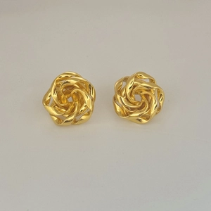 Detail of woven sphere earrings in polished gold metal with a rose knot design