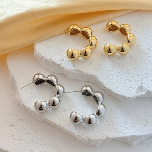 Fashionable C-shaped bubble textured metal hoop earrings in gold and silver finishes