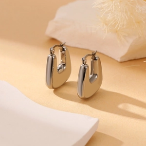 Minimalist silver geometric U-shaped chunky hoop earrings on decorative stone