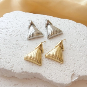 Minimalist gold and silver triangular earrings with textured ripples on stone