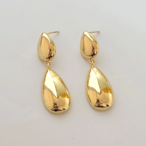 Detail of elegant gold double-layer teardrop earrings with a polished mirror finish