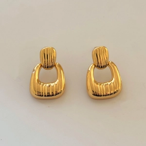 Detail view of gold geometric textured earrings with retro minimalist hollow ring design
