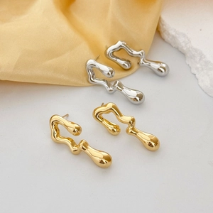 Detailed comparison of gold and silver irregular fluid hollow earrings on a stone base