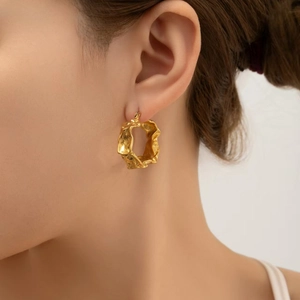 Minimalistische goldene Creolen im Lava-Design mit strukturierter Metalloberfläche