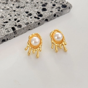 Irregular liquid gold geometric stud earrings with white pearl center on grey stone