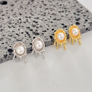 Macro view of geometric irregular pearl stud earrings with molten liquid metal drip effect