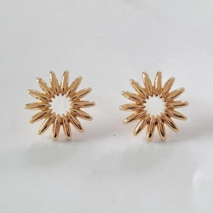Top view of gold sunflower stud earrings with radial patterns and hollow center details