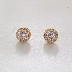 Detailed close-up of gold halo stud earrings with round-cut cubic zirconia and four-prong setting