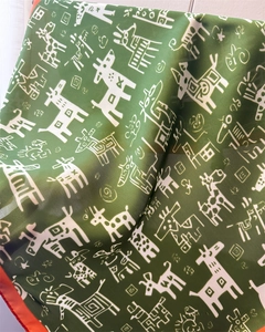 Macro detail of olive green silk scarf with white animal prints and orange edges