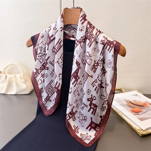 Elegant white square silk scarf with red deer print hanging on a wooden hanger