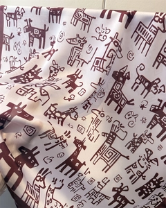 Detail of white silk scarf showing tribal animal print and smooth satin texture