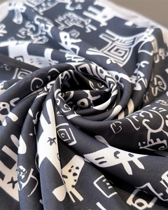 Detail of silk-like scarf featuring black and white abstract print and smooth texture