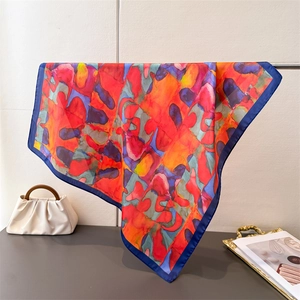Détail du foulard en soie aux motifs abstraits aquarelle et bordure en satin bleu