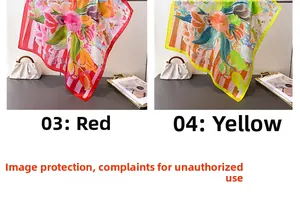 Detailed view of floral silk scarves in red and yellow draped on a luxury desk