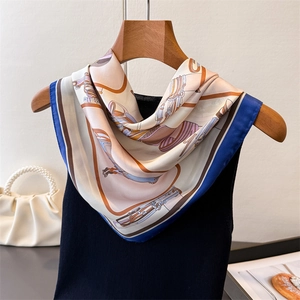 Vista dettagliata di un foulard in seta con stampa equestre e eleganti bordi blu