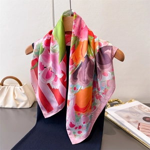 Elegant floral print faux silk square scarf draped on a wooden hanger for styling