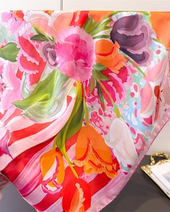 Detailed close-up of vibrant floral print silk scarf with smooth draped texture