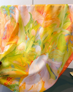 Detail of silk scarf showing vibrant tulip print and smooth satin texture with fine edges