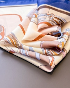 Dettaglio macro del foulard in seta con stampe equestri e finitura satinata