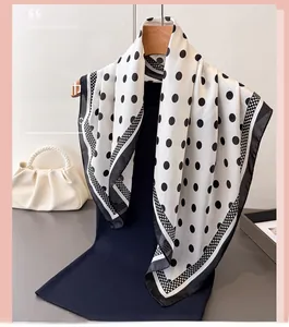 Detailed view of polka dot silk scarf draped on a hanger with pearl handbag accent
