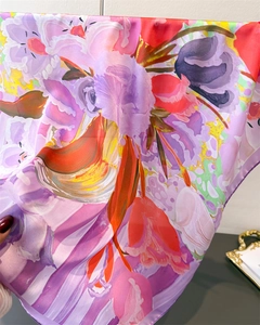 Close-up of artistic floral silk scarf showing light texture and purple edges