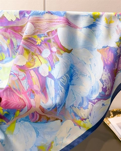 Close-up of vibrant floral print silk scarf featuring elegant draped texture and hemmed edges