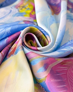 Macro detail of silky satin fabric showing colorful abstract prints and soft drape