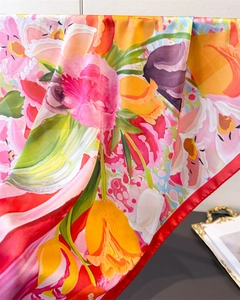 Close-up of floral print silk scarf featuring vibrant tulips and red stitched edges
