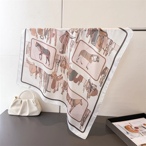 Dettaglio di foulard in raso con motivi equestri e stampa cavallo su gruccia in metallo