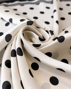 Macro shot of silk-like scarf featuring black polka dots and wave edge texture