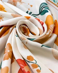Close-up of elegant floral print on silky satin fabric with orange and red flowers