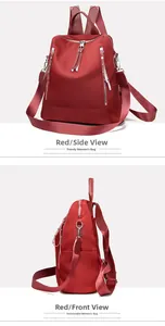 Detail view of red oxford cloth backpack showing side profile and metal zippers