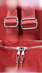 Detail view of the durable red Oxford fabric backpack with silver metal buckles and zippers