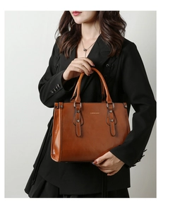 Détail du sac à main en cuir verni marron avec logo doré et finitions rivets latéraux