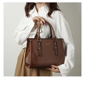 Détail du sac cabas en cuir verni marron foncé avec rivets et sangles décoratives