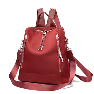 Deep red Oxford cloth backpack with silver zippers and rivet decor on white background