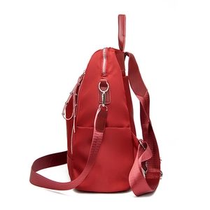 Water-resistant red nylon backpack for women with silver zippers and side pockets