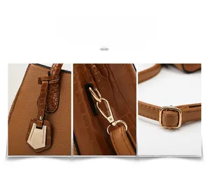 Detail of brown crocodile pattern handbag featuring gold metal clasp and adjustable strap
