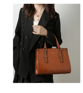 Détail du sac à main en cuir verni marron avec rivets dorés et logo élégant