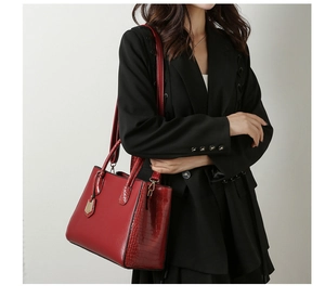 Detail of red crocodile texture tote bag with gold hardware and removable shoulder strap
