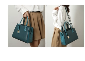 Detail of dark green crocodile embossed tote bag with gold hardware and shoulder strap
